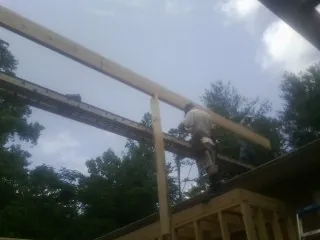 Carpenter setting a ridge beam over a new addition frame — Ice Dam Removal by Roofing Brothers in Bourneville